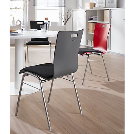 Drie stoelen in een kantoor, één grijs, één rood, de andere zwart. Chromen poten, zwarte zittingen.
