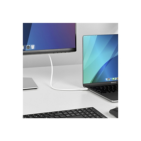 Un MacBook Pro est connecté à un moniteur externe via un câble USB-C sur un fond blanc. Un clavier et une souris sont également visibles.