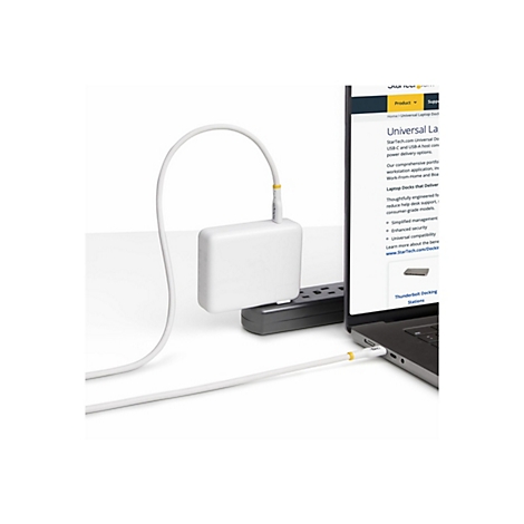 Un chargeur d'ordinateur portable blanc connecté à un ordinateur portable via un câble. Un site Web sur les stations d'accueil pour ordinateurs portables est affiché sur l'écran de l'ordinateur portable.