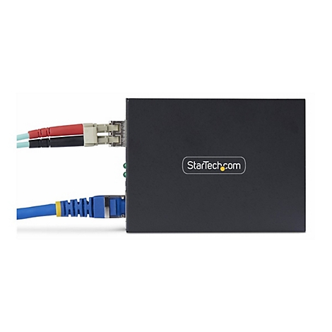 Schwarzer Netzwerk-Switch mit eingesteckten Kabeln. Auf dem Switch befindet sich der Schriftzug 'StarTech.com'.