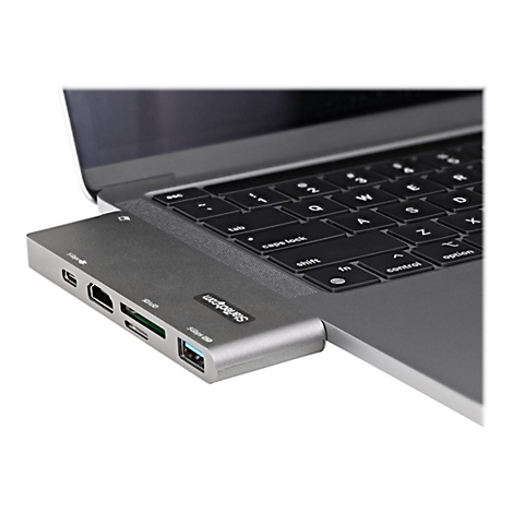 Grauer USB-C-Hub, angeschlossen an einem Laptop, mit HDMI, USB-A, Kartenleser und Ladeanschluss.