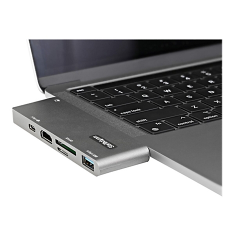 Ein silberner USB-C-Hub, der an einem Laptop angeschlossen ist. Auf dem Hub sind verschiedene AnschlÃ¼sse deutlich zu sehen.