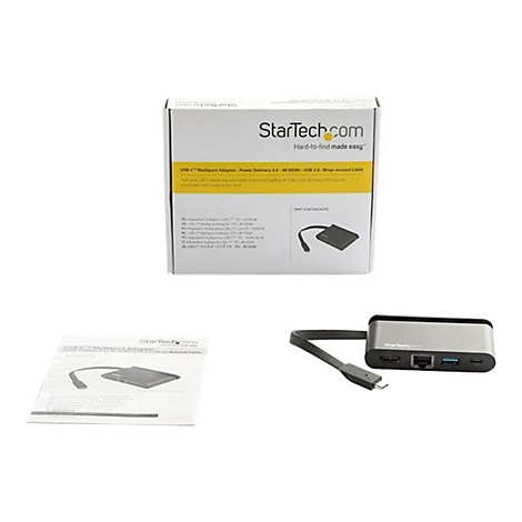 Ein USB-C-Multifunktionsadapter mit Verpackung und Handbuch. Das Produkt ist silber-schwarz.