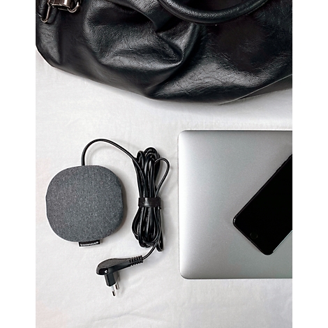 Un coussin chauffant gris, un câble noir, un ordinateur portable, un smartphone et un sac noir reposent sur une surface blanche.