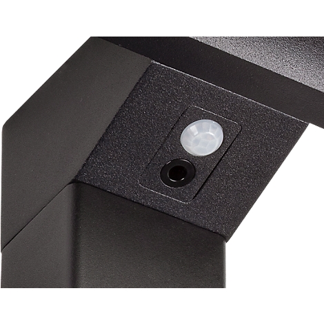 Nahaufnahme: Schwarze Ecke mit Bewegungsmelder und Loch, vermutlich ein Teil einer Außenleuchte.