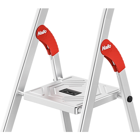 Close-up of a silver step ladder with red handles and the brand name "Hailo".