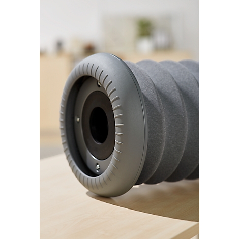 Close-up of a grey fascia roller. The ridged roller lies on a wooden surface.