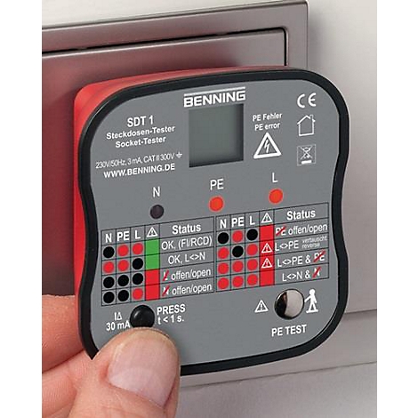 Een rode stopcontacttester met grijze bedieningselementen wordt door een hand voor een stopcontact gehouden. De tester toont verschillende resultaten.