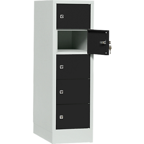 A white cabinet with four black compartments, one open. Keys are in the lock.