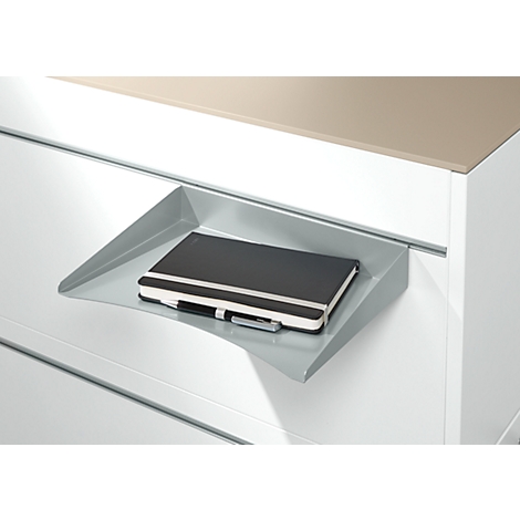 Gray shelf with notebook and pen. The background shows a white drawer and a brown surface.