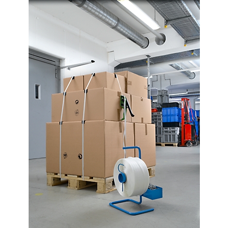 Cardboard boxes stacked on a pallet, wrapped with white straps; next to them a tape dispenser.