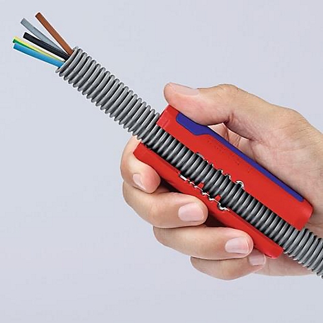 Hand holding cable with red and blue tool, grey corrugated pipe, and colored cable ends.