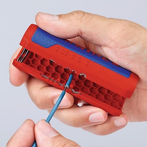 A hand holds a red and blue wire stripper. A blue cable is being processed.