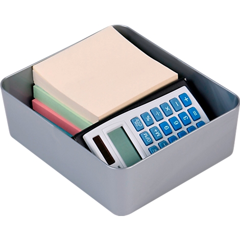 Grijze bureaulade met plakbriefjes en een rekenmachine. De rekenmachine rust op roze, groene en beige briefjes.