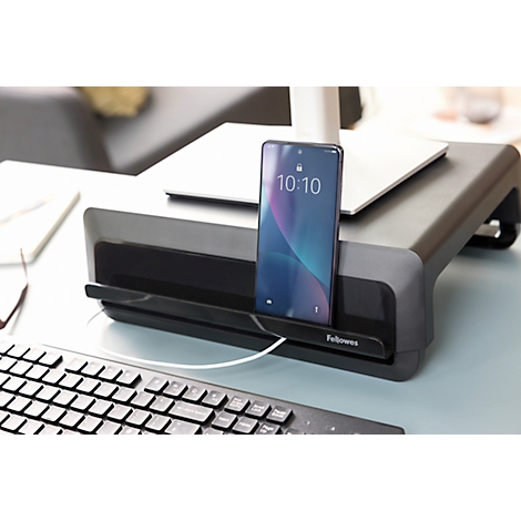 Un smartphone est dans un support sur un support d'écran. L'heure 10:10 est visible sur l'écran.
