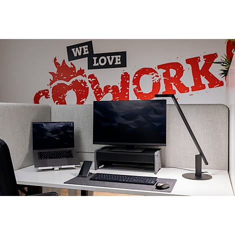 Bureau avec ordinateur portable, écran, lampe et le texte "We Love Cowork".