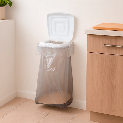 Une poubelle murale avec un couvercle ouvert et un sac en plastique à l'intérieur. À droite, un élément de cuisine.
