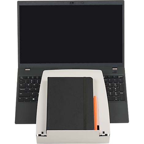 Ordinateur portable sombre, en dessous une tablette blanche avec un carnet noir et un stylo orange.