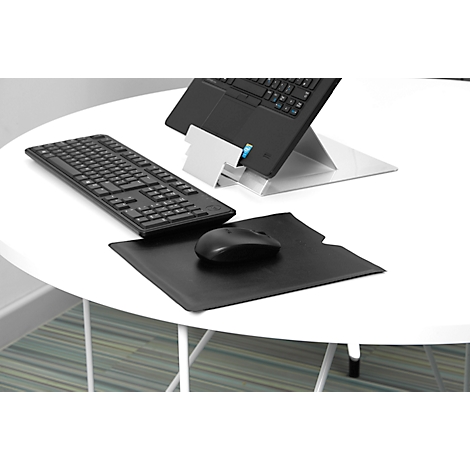 Clavier d'ordinateur noir, souris et ordinateur portable sur une table blanche. L'ordinateur portable est sur un support argenté.