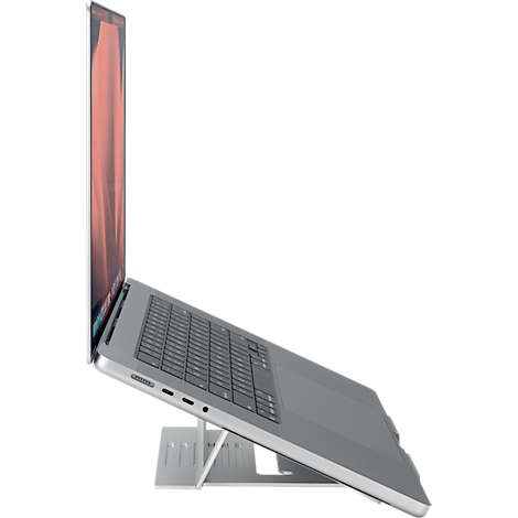 MacBook gris sur un support pour ordinateur portable. L'écran est ouvert et le fond est blanc.