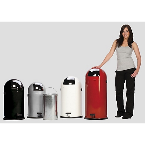 Femme à côté de poubelles de différentes couleurs. Elle touche la poubelle rouge.