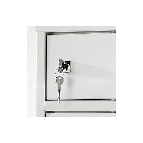 Close-up of a white cabinet with a key in the lock.