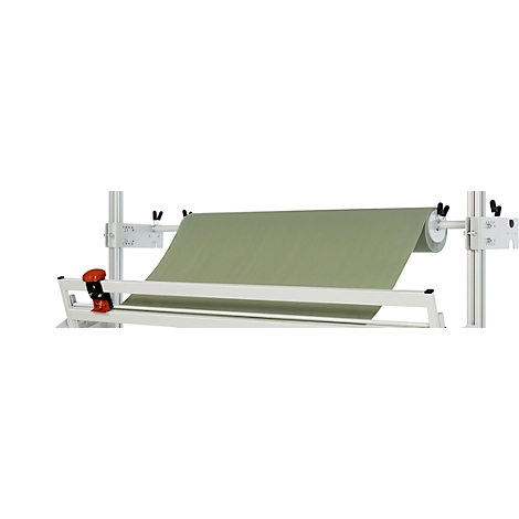 Une machine tenant un rouleau de tissu vert clair. Un cadre métallique supporte le rouleau et permet de dérouler le tissu.