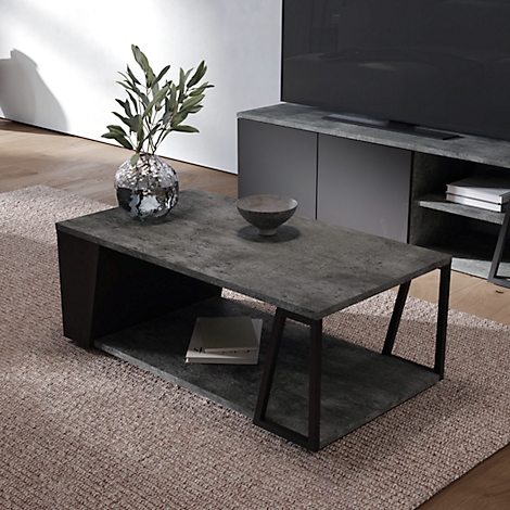 Table basse grise avec cadre noir. Sur le plateau, un vase avec des branches et un bol. Un livre est posé sur l'étagère inférieure.