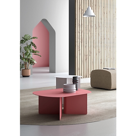Deux tables basses modernes aux formes organiques, rose et blanche, posées sur un tapis rond dans une pièce élégante.