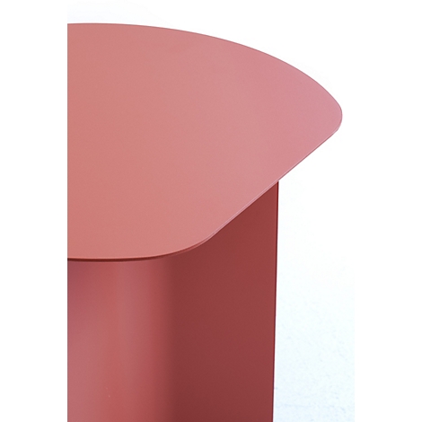 Gros plan sur un plateau de table arrondi couleur corail d'une table d'appoint en métal sur fond blanc.
