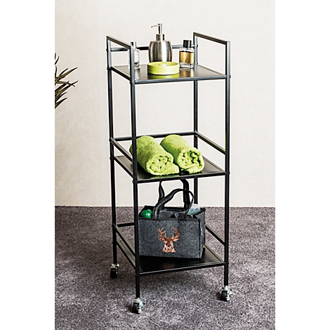 Étagère de salle de bain noire à trois étagères. Serviettes, savon, flacons et un sac avec un motif de cerf sont placés.