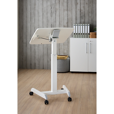 Bureau debout blanc réglable en hauteur avec roulettes. Plateau légèrement incliné, en arrière-plan mur gris, armoire, dossiers.