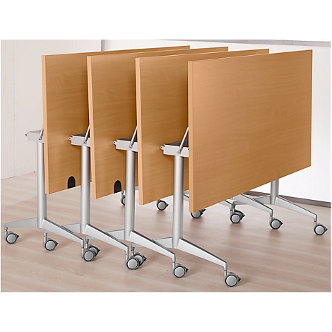 Rangée de quatre tables pliantes avec des plateaux brun clair et des cadres argentés sur roulettes.