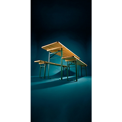 Ensemble table et bancs de brasserie en bois avec structure en métal vert sur fond bleu sombre.