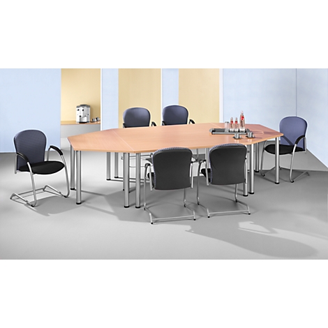 Conference table with six chairs in a bright room, coffee machine in the background.