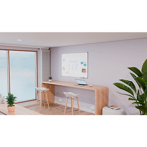 Bureau avec meubles en bois clair et un tableau blanc. Ordinateur portable sur la table, deux tabourets de bar devant. Plantes, lumière du jour.