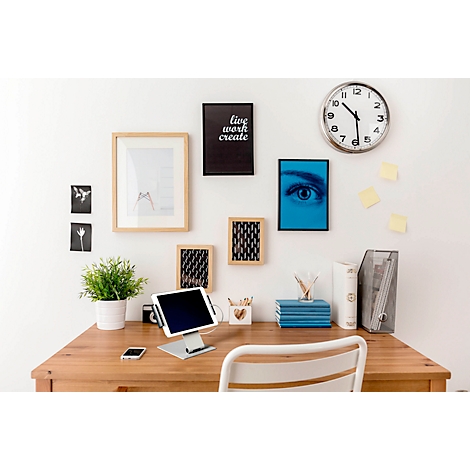 Desk with tablet, plants, pictures and clock. On a black picture says: live work create.