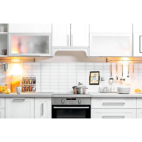 A modern white kitchen with stainless steel appliances and accessories.