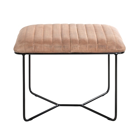 Banc rembourré marron avec cadre noir. Sur celui-ci se trouvent des lunettes, un smartphone et des serviettes. Sac à main, écharpe accrochés au mur.