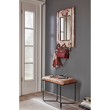 Un tabouret avec une assise marron et un cadre noir. Un petit objet repose sur le tabouret. A côté, une écharpe bleue. Il y a des chaussures par terre.