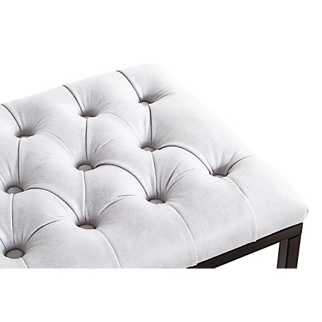 Banc gris avec assise matelassée et cadre noir. Une couverture et une chaussure sont dessus.