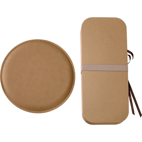 Assiette ronde marron à côté d'une longue boîte marron avec un ruban. Assiette et boîte sont en cuir et en carton.