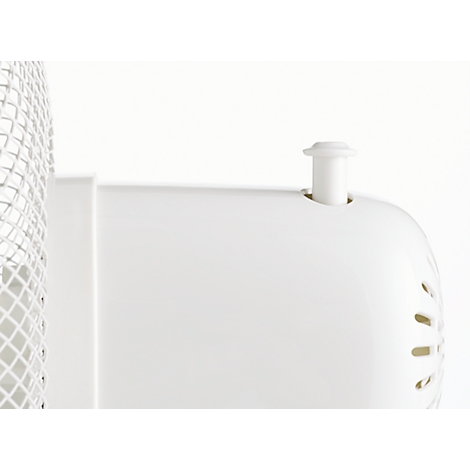 Close-up van een wit ventilator detail. Een witte knop steekt uit de behuizing. Kleine ventilatiegaten zijn rechts te zien.