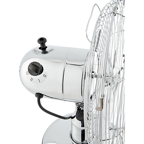 Close-up van een verchroomde tafelventilator met bedieningsknoppen en beschermrooster. De schakelaar staat in stand 0, onder de cijfers I, II en III.