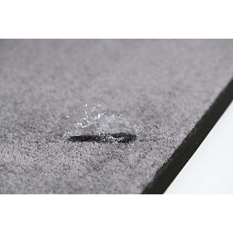 Gros plan sur une surface textile grise avec une petite fente ou coupure sombre.