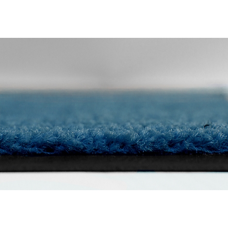 Gros plan sur une surface de tapis bleu foncé texturée.