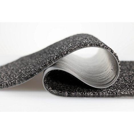 Un revêtement de sol gris à surface texturée est plié en boucle, laissant apparaître le dessous de couleur claire.