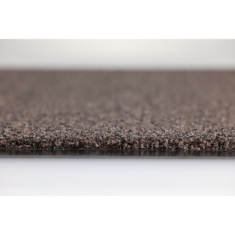 Gros plan sur la texture d'une moquette marron foncé vue de côté avec sous-couche visible.