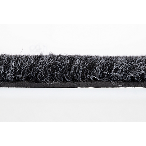 Gros plan d'un ruban d'étanchéité de porte noir avec de fines fibres gris clair sur fond clair.