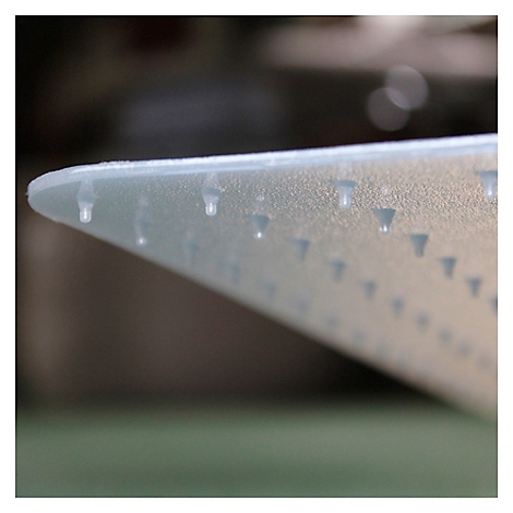 Gros plan d'un objet transparent et effilé, avec des éléments en forme de goutte uniformément répartis. L'arrière-plan est flou.